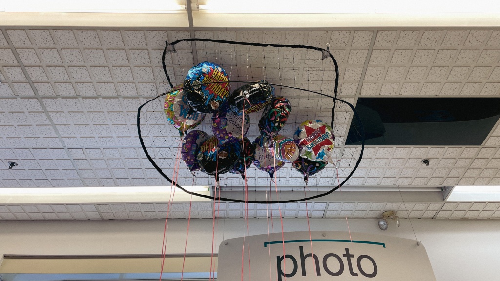 A group of celebration balloons corralled in a net. In the bottom-right are the words 'photo'.